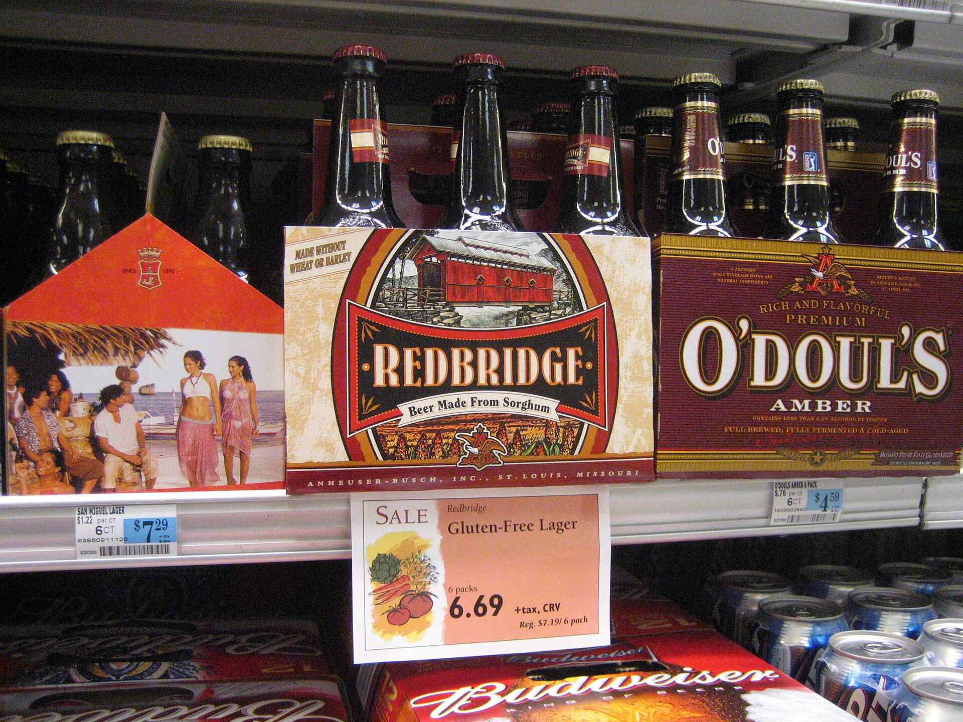 Bottles of gluten-free beer on a market shelf with price labels.